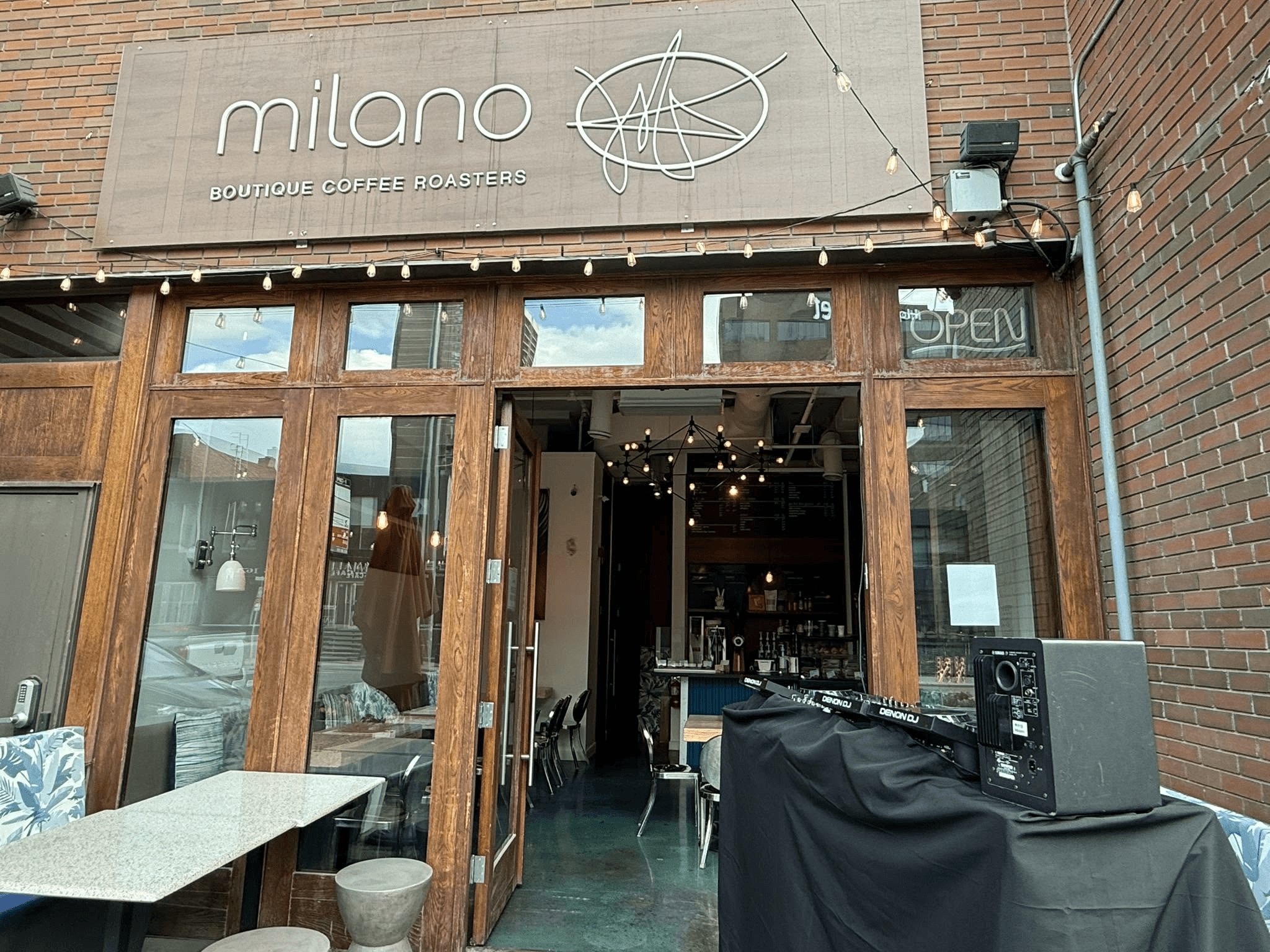 The café’s open wood-framed doors and interior, cropped below the storefront sign
